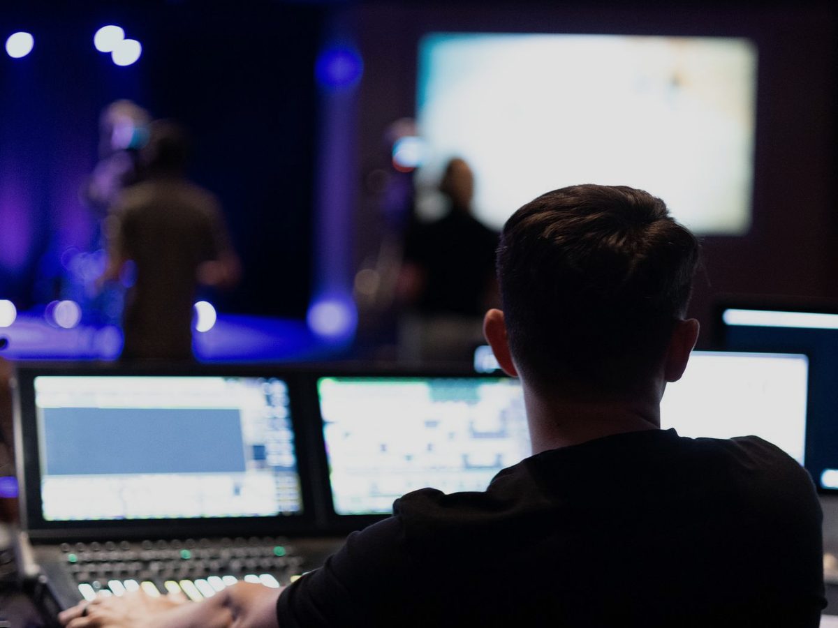 An engineer working at a lighting and sound console during a live event.